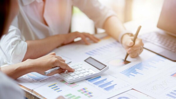 Close-up Businesswomen working together, calculates and estimates business investment turnover on financial data report chart and graph