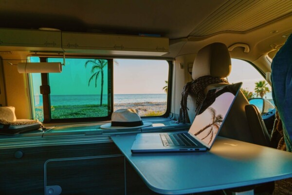 Close-up of laptop with reflection on screen in motor home against sea during summer