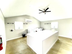 Spacious laundry room with folding and hanging rods.