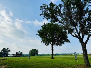 A peaceful RV spot with trees and open spaces all around.